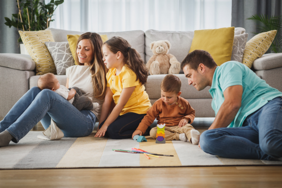 A family playing together on the living room floor