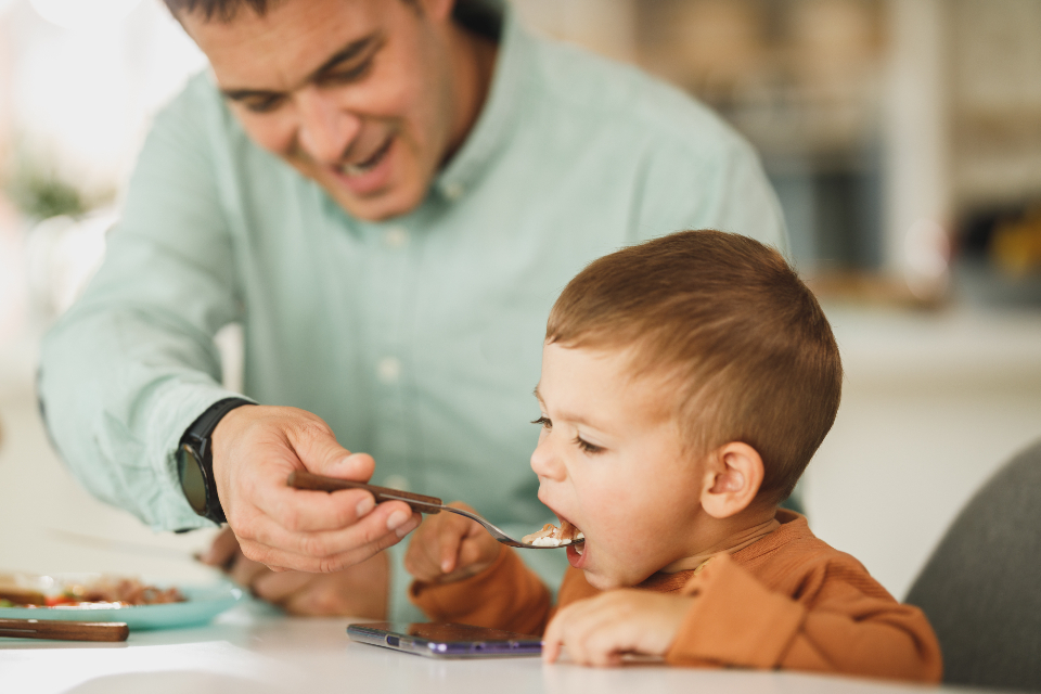 Child mid-laugh at the breakfast table