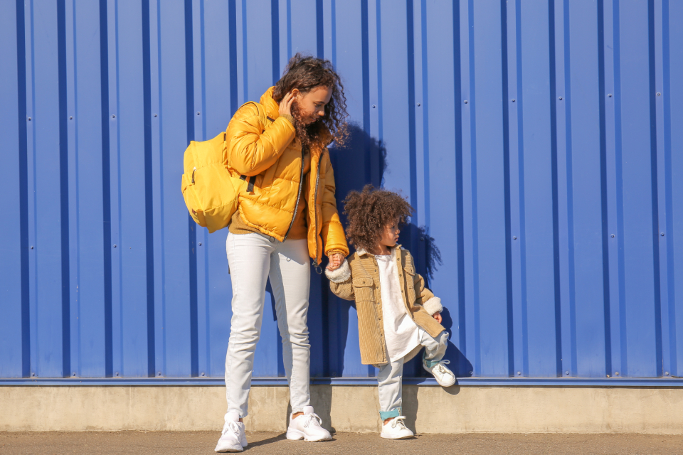 Preschooler holding a parent's hand, growing independence alongside connection