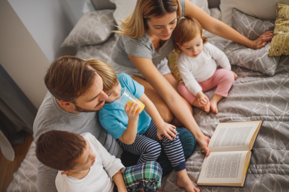 Parent tucking a child in, keeping bedtime steady between two homes
